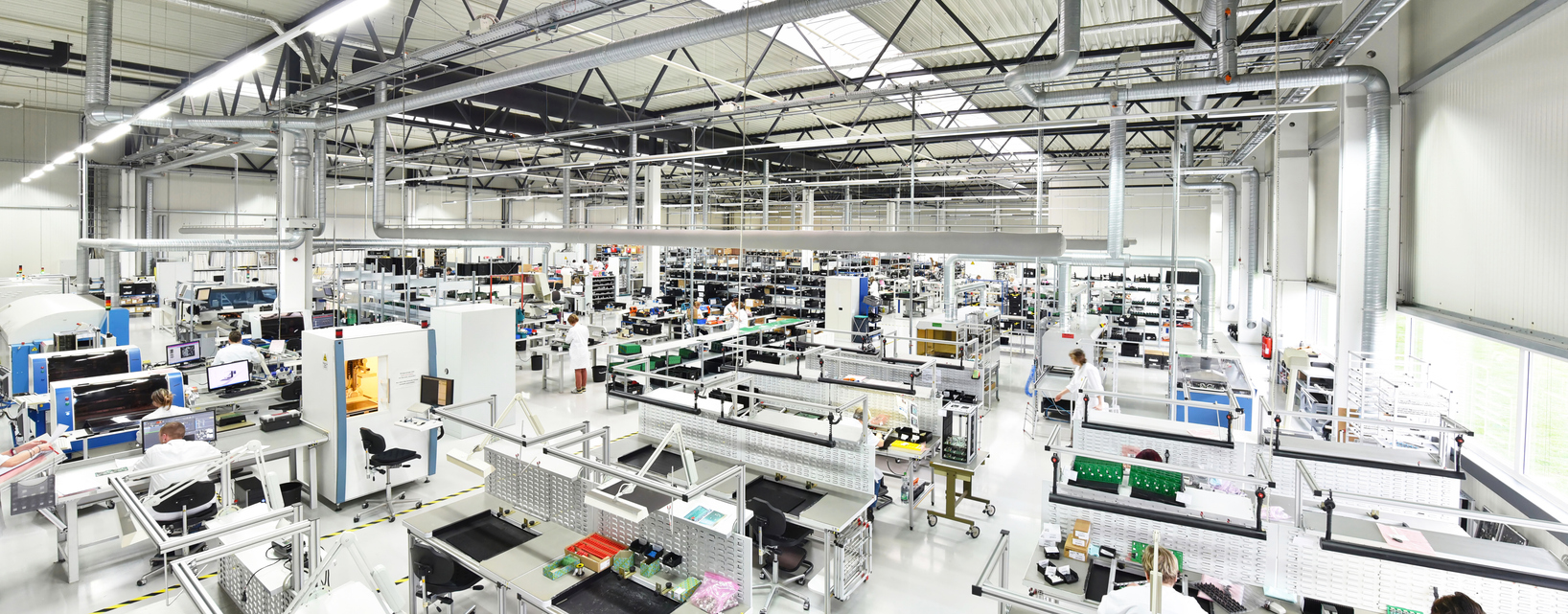 Wide interior view of a bright industrial production facility